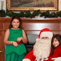 Two sisters sitting with Santa.